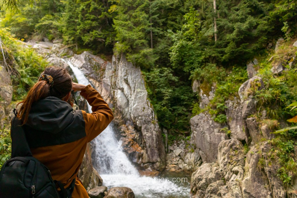 Émeline de dos en train de photographier la cascade Loloia du parc National de Retezat, Roumanie, septembre 2021