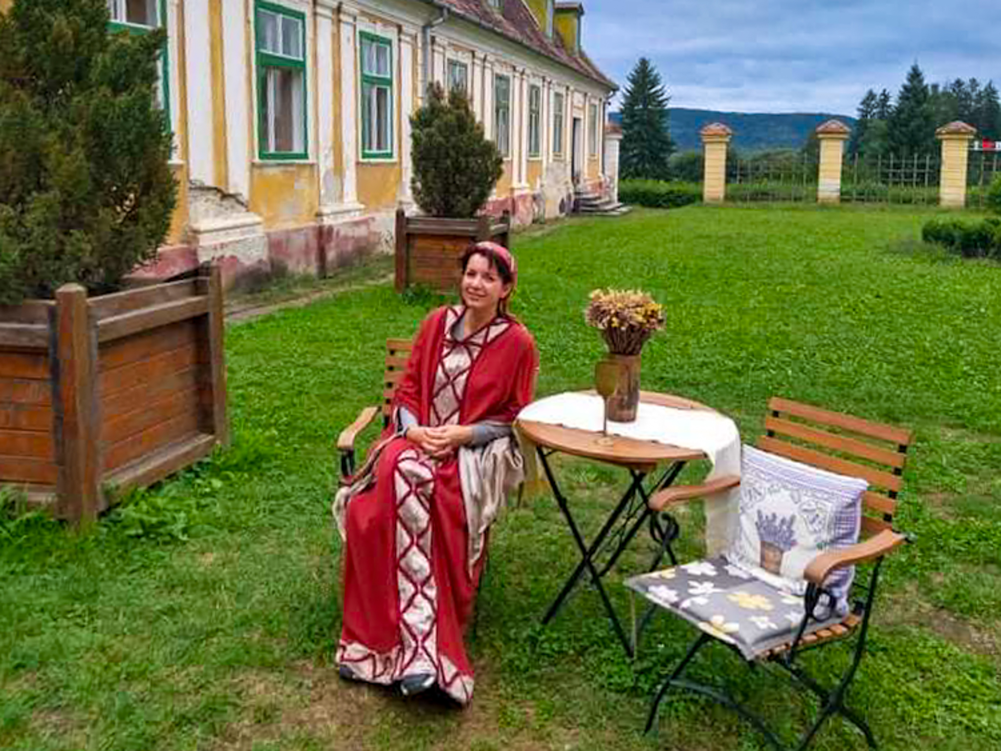 Scène de reconstitution historique avec un personnage en costume médiéval dans la cour d'un palais médiéval transylvain