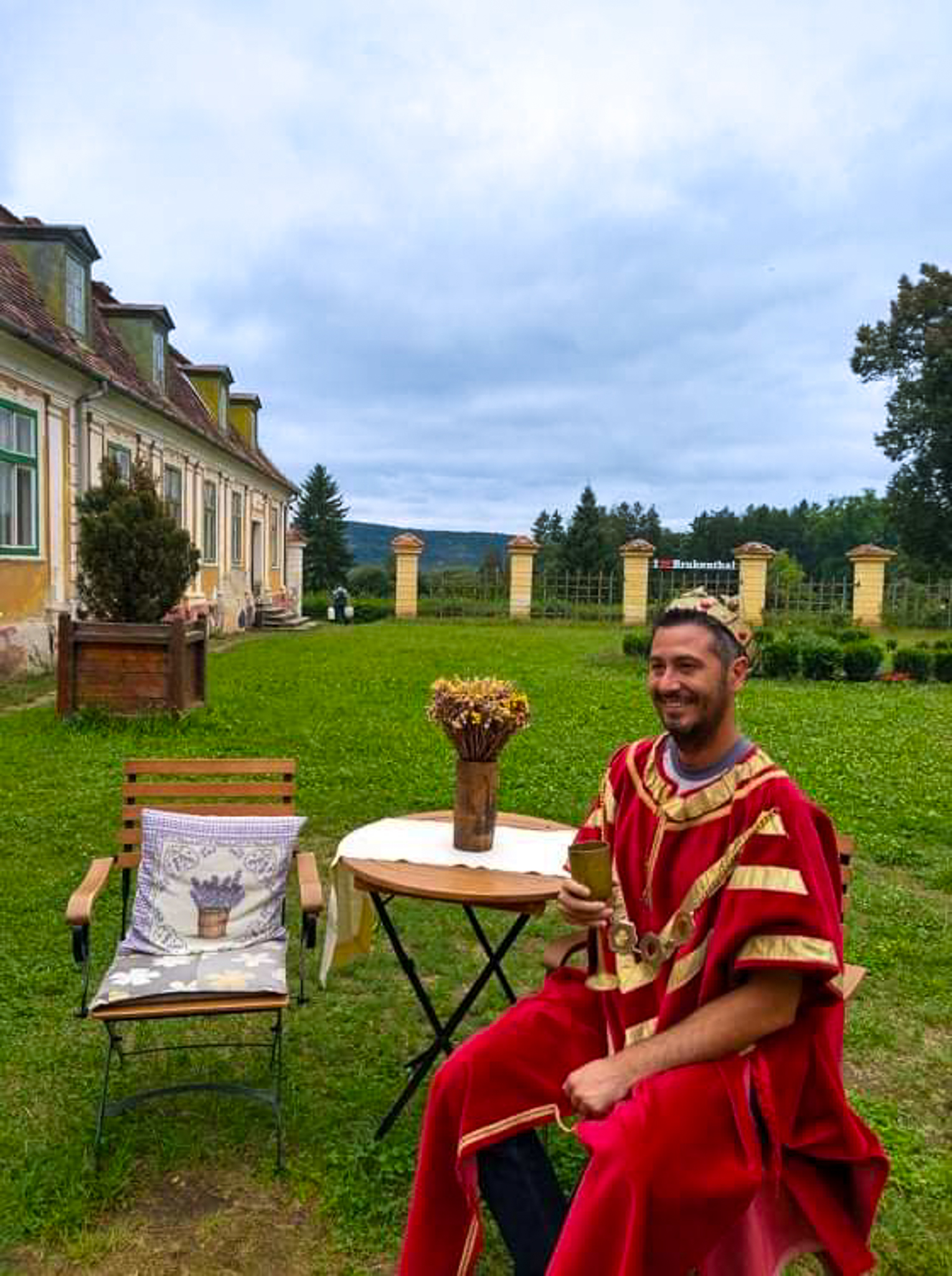 Scène de reconstitution historique avec un personnage costumé en roi dans la cour d'un palais médiéval de Transylvanie.