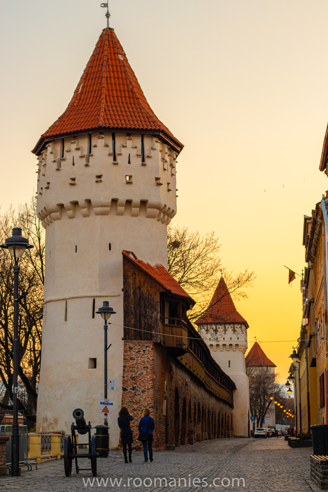 La rue Cetații de Sibiu avec ses 3 tours médiévales et 2 touristes admirant le patrimoine. 